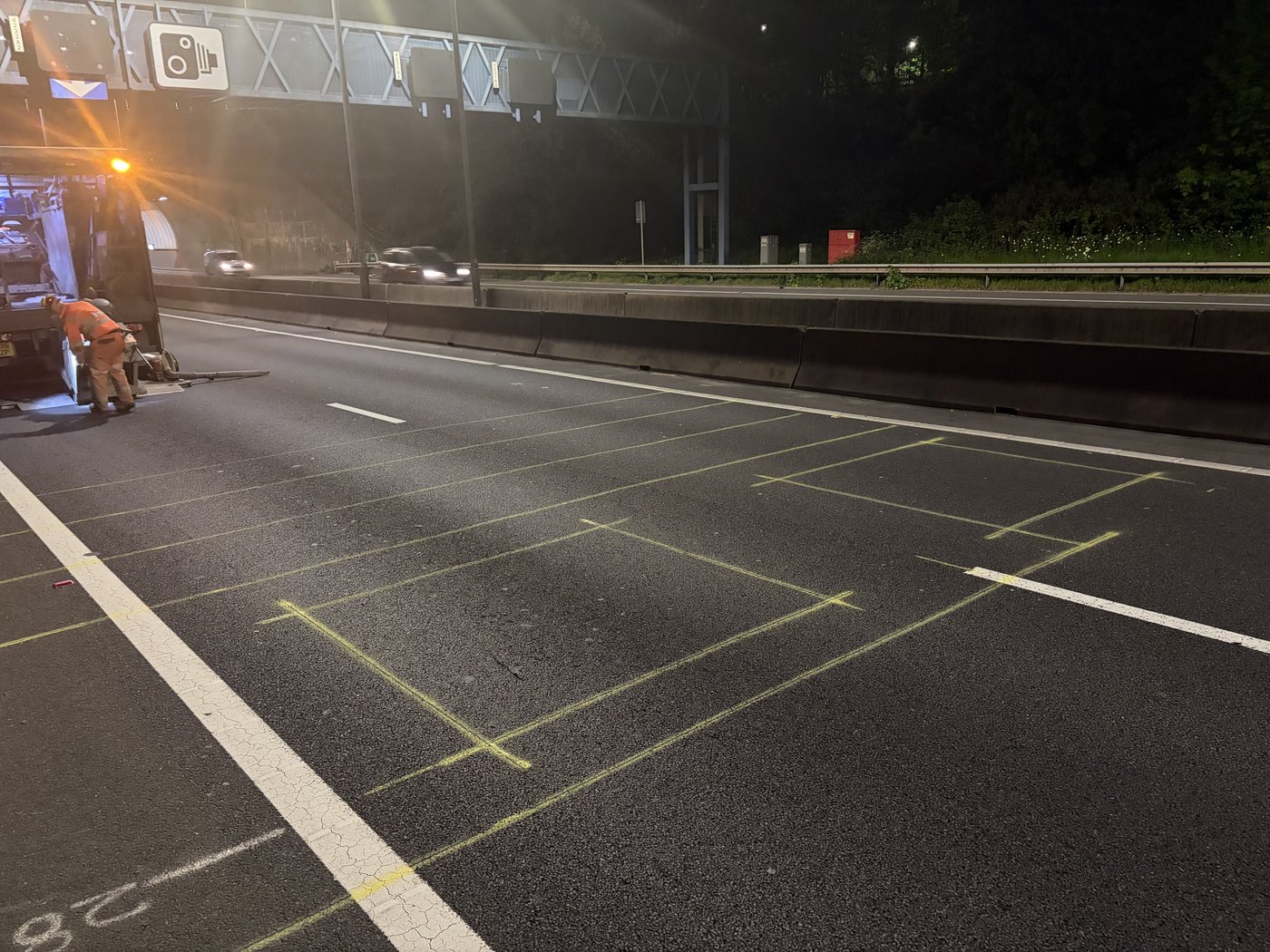Loop marking laid out at night on a motorway carriageway, work vehicle alongside