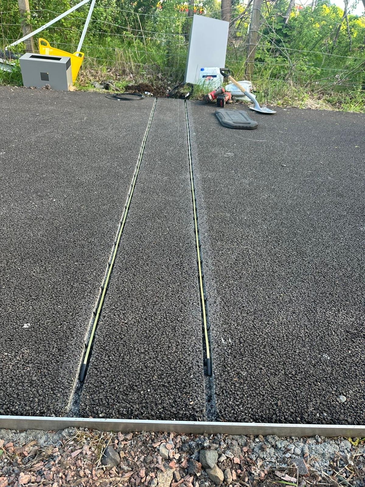 Close-up of piezo sensor leads embedded in saw-cut channels in the road surface