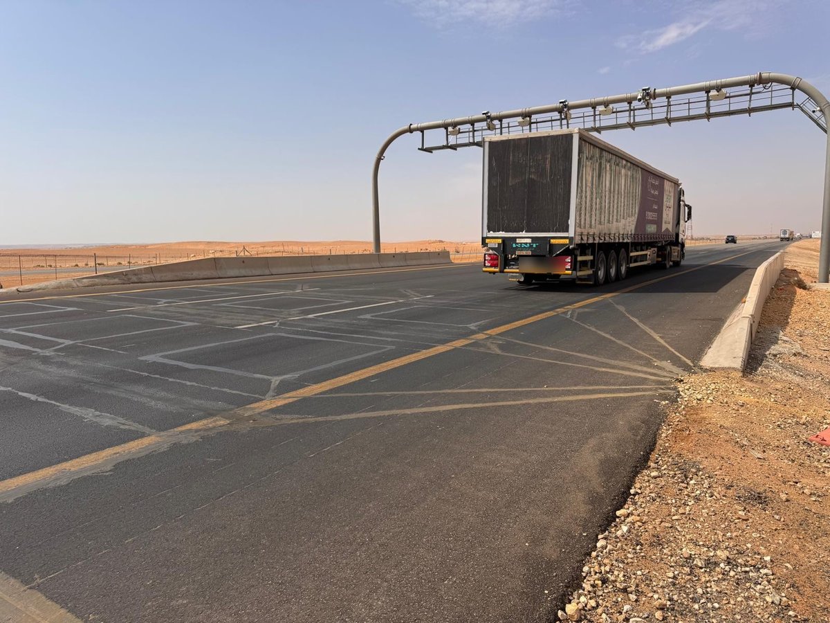 WIM and ANPR gantry over a desert highway with a truck passing underneath